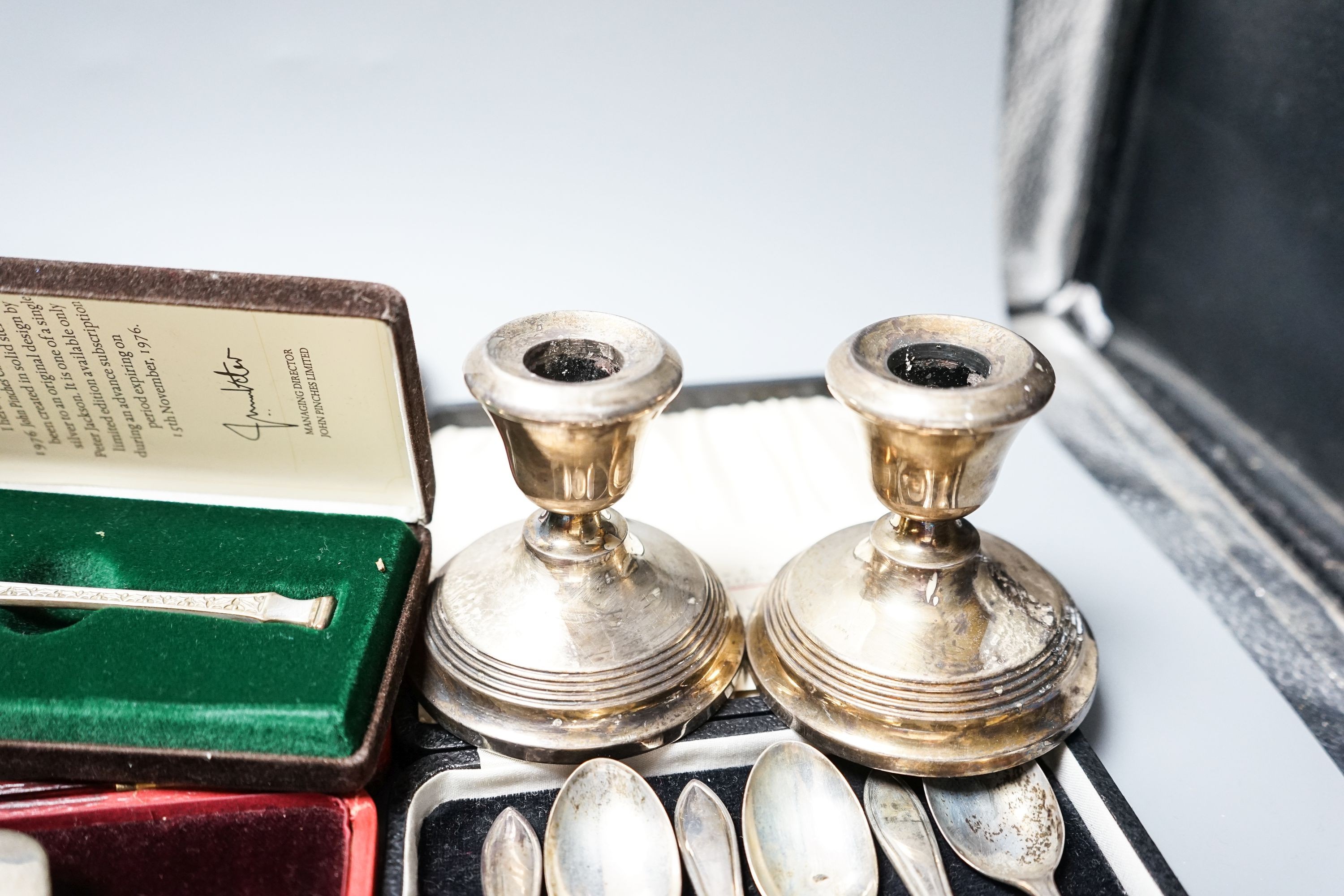 A cased pair of four 1920's silver napkin rings, four other cased items including butter shell and a pair of silver mounted dwarf candlesticks.